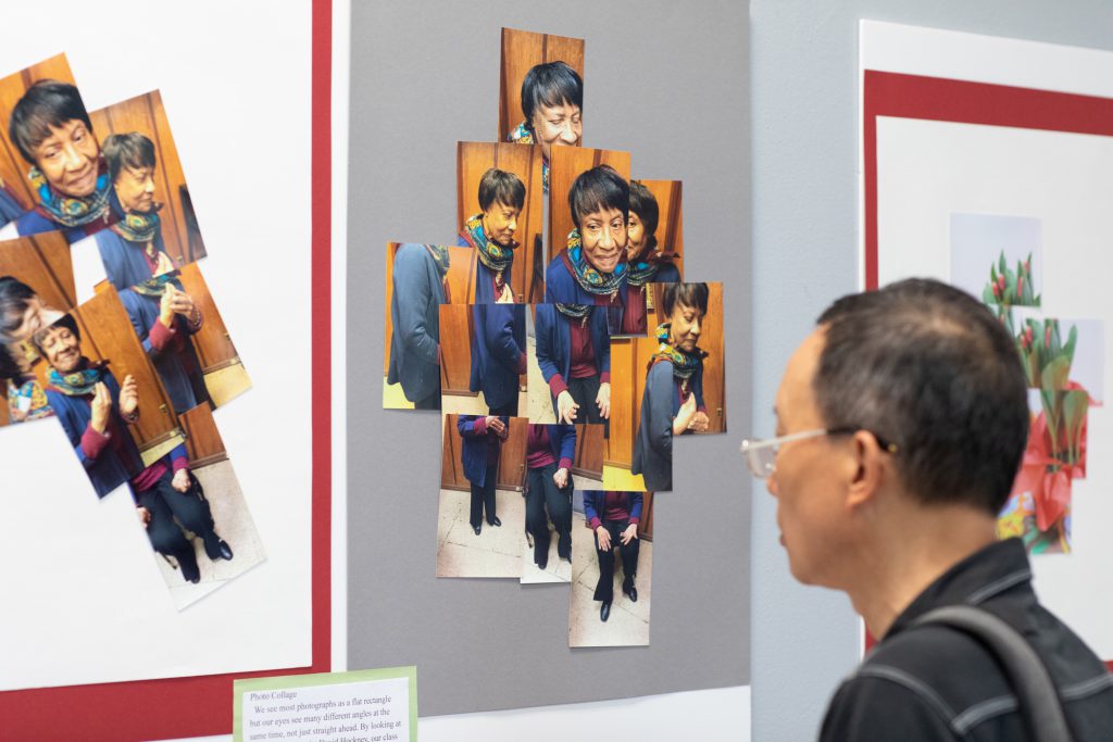 A photo of a man looking at an exhibit of photo collage artwork.